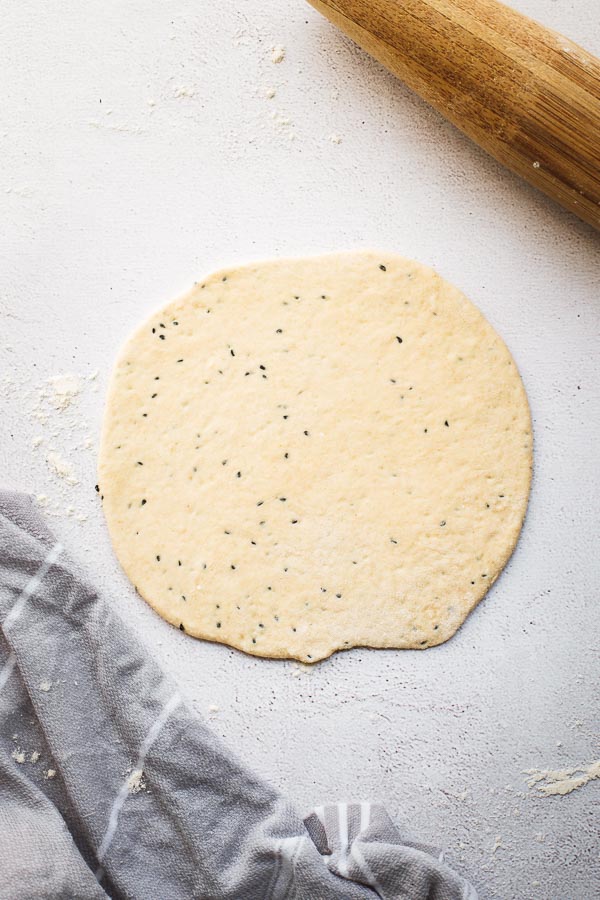 Yoghurt flatbread dough rolled out with rolling pin.