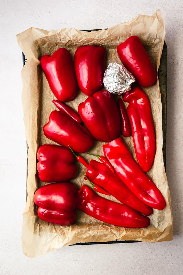 Raw red peppers in a tray, ready to be roasted.