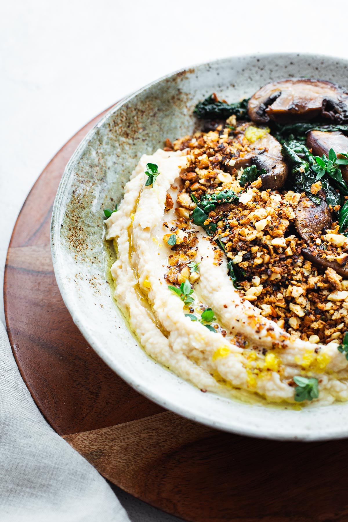 Butter bean mash (pureed butter beans) with crunchy almond bread crumbs and sautéed mushrooms and black kale.