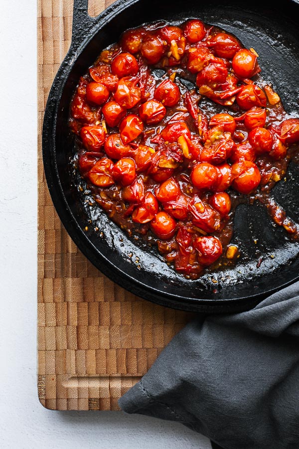 Sweet and spicy burst cherry tomato sauce in a skillet.