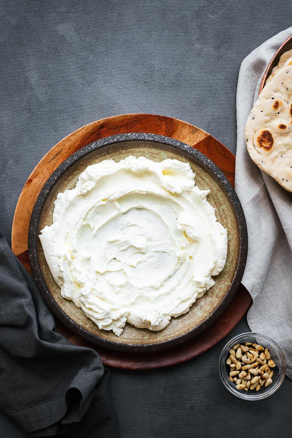 Homemade labneh spread with the back of a spoon to form waves.