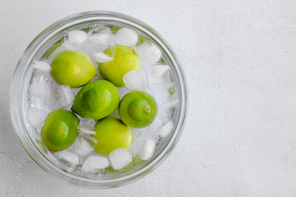 Blanched fresh limes in an ice bath.