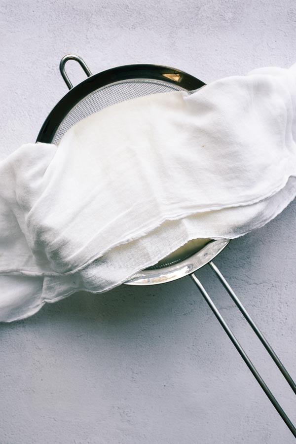 Making labneh at home with a sieve and muslin.