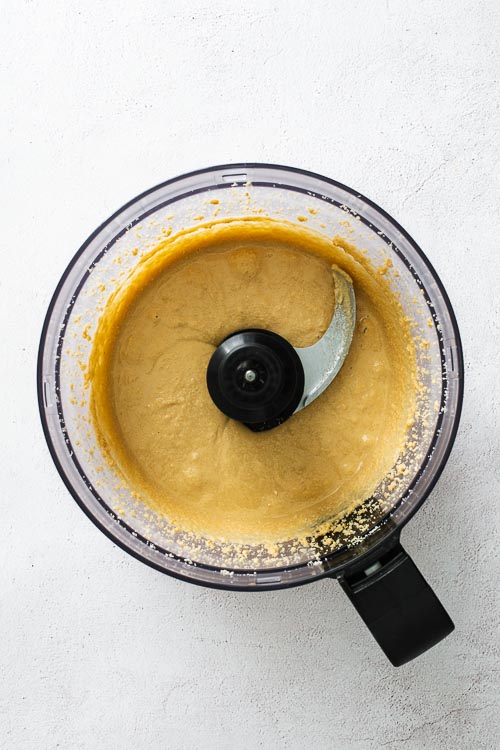 Almost smooth tahini paste in a food processor viewed from above.