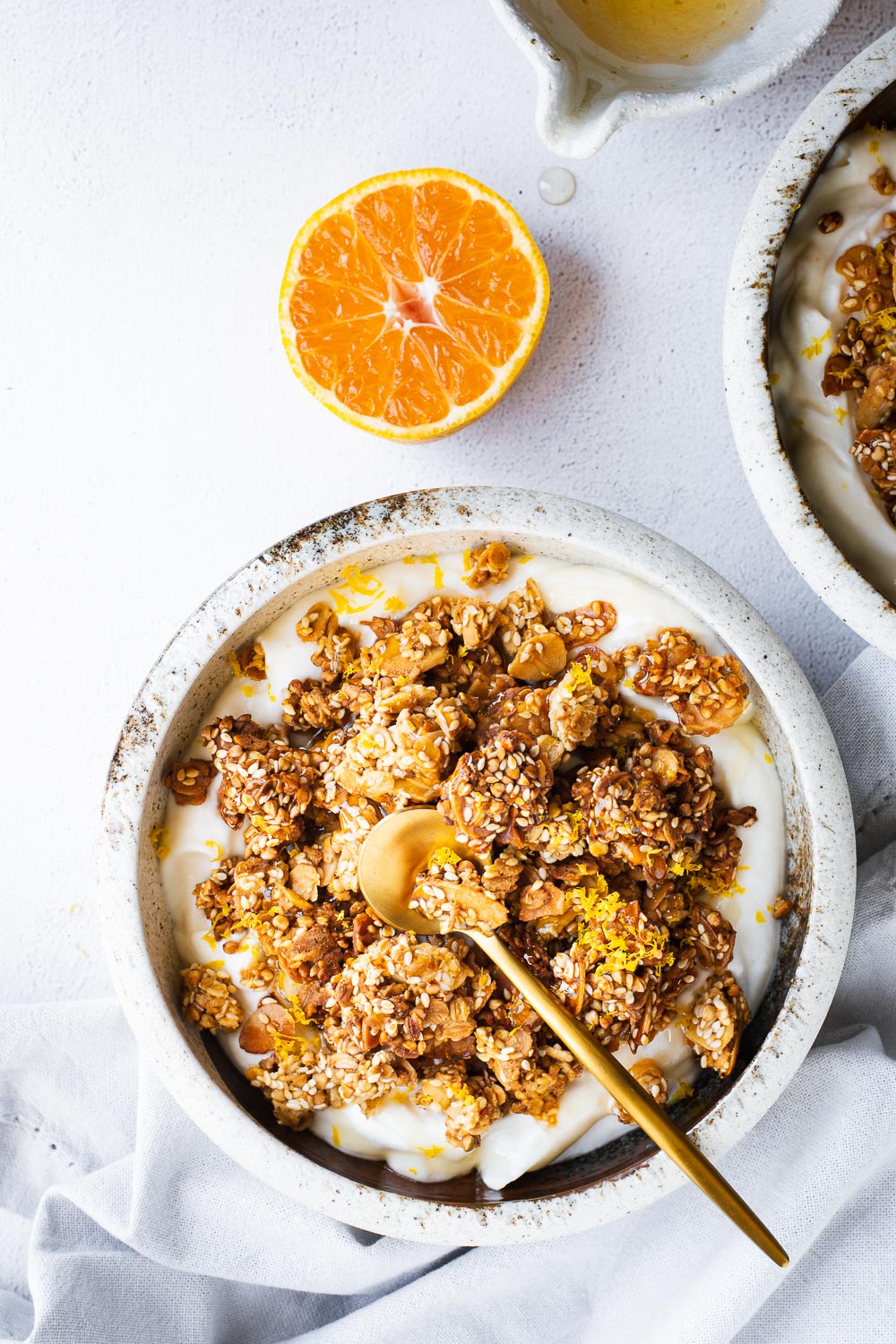 Tahini granola bowls with with yoghurt, orange and honey viewed from top down.