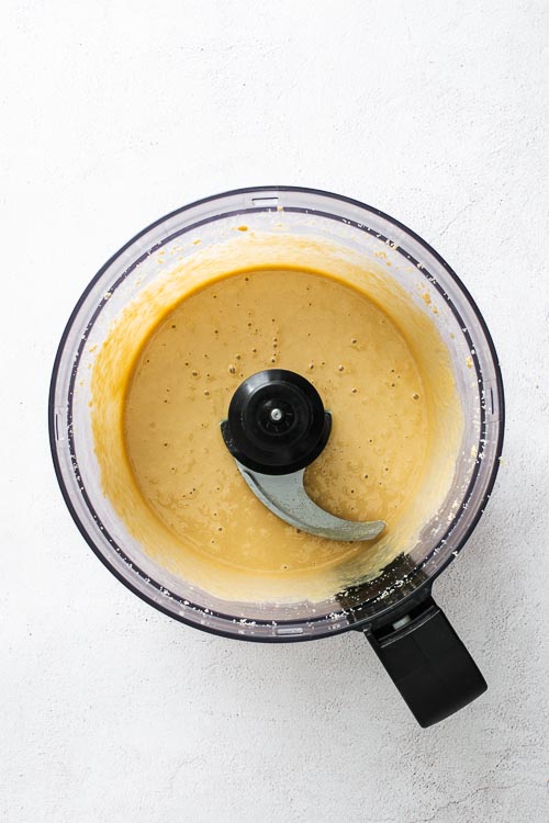 Smooth and bubbly tahini in a food processor after 6 minutes of processing.