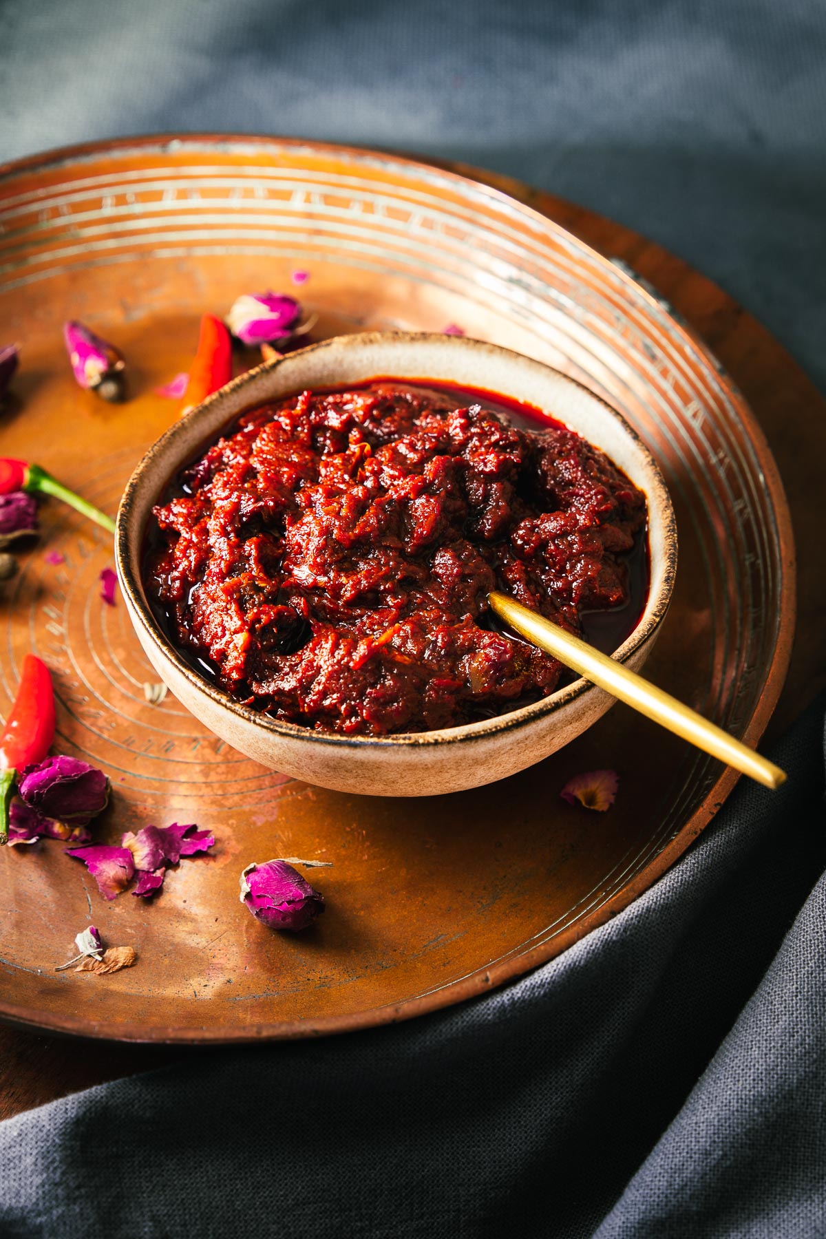 Homemade rose harissa paste in a bowl with gold spoon.