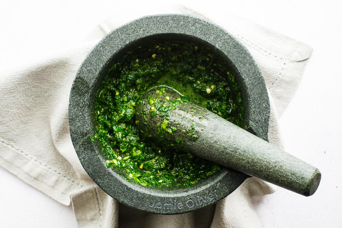 Zhoug sauce in a pestle and mortar.