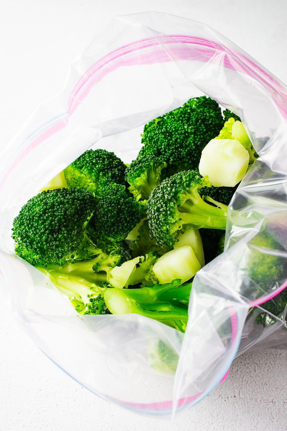 Frozen broccoli florets in a freezer bag.