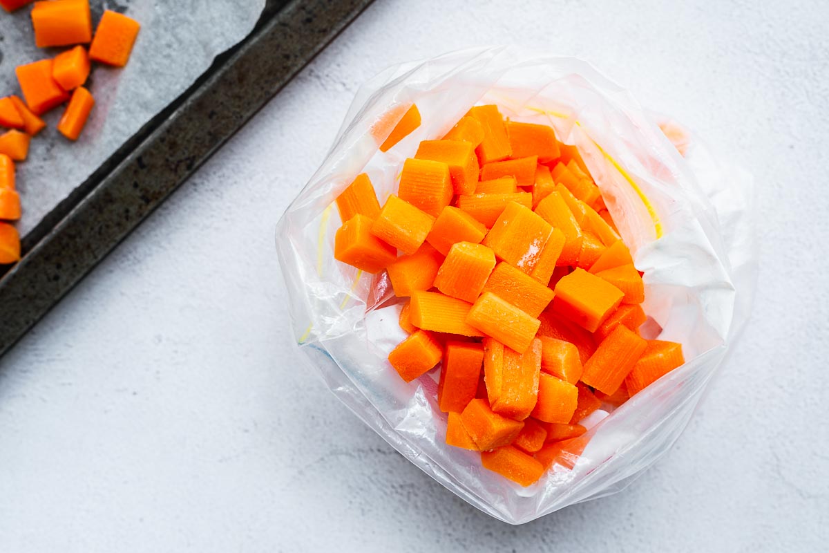 Flash frozen carrots are placed in a freezer bag.