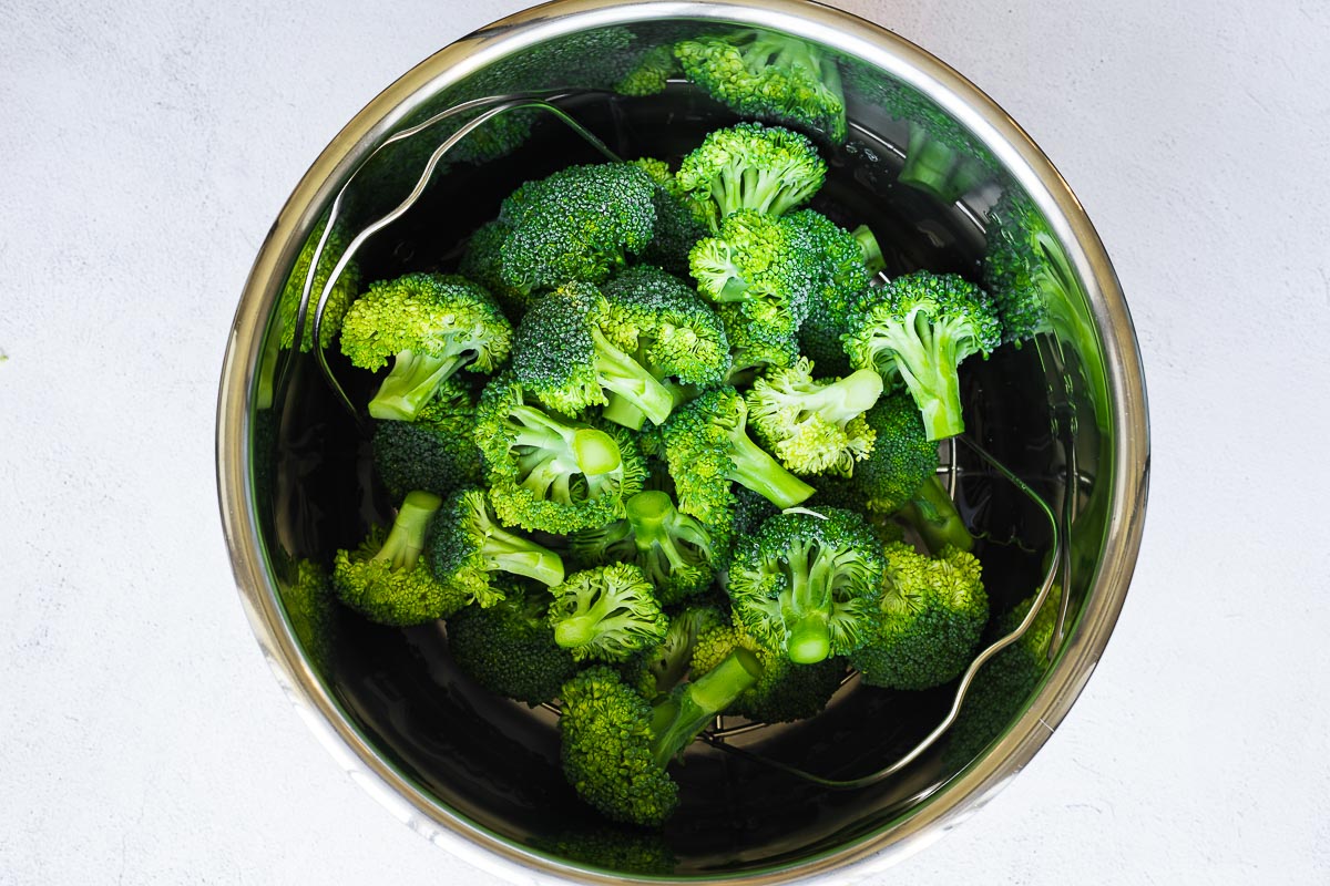 An Instant Pot insert filled with broccoli florets, viewed from above.