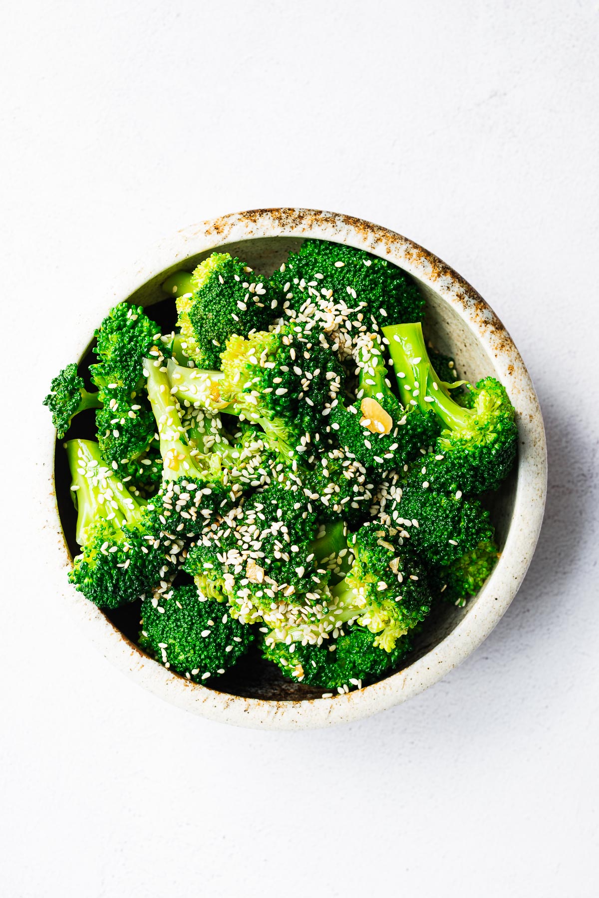 A bowl of Korean sesame broccoli banchan with sesame seeds and a sesame oil dressing.
