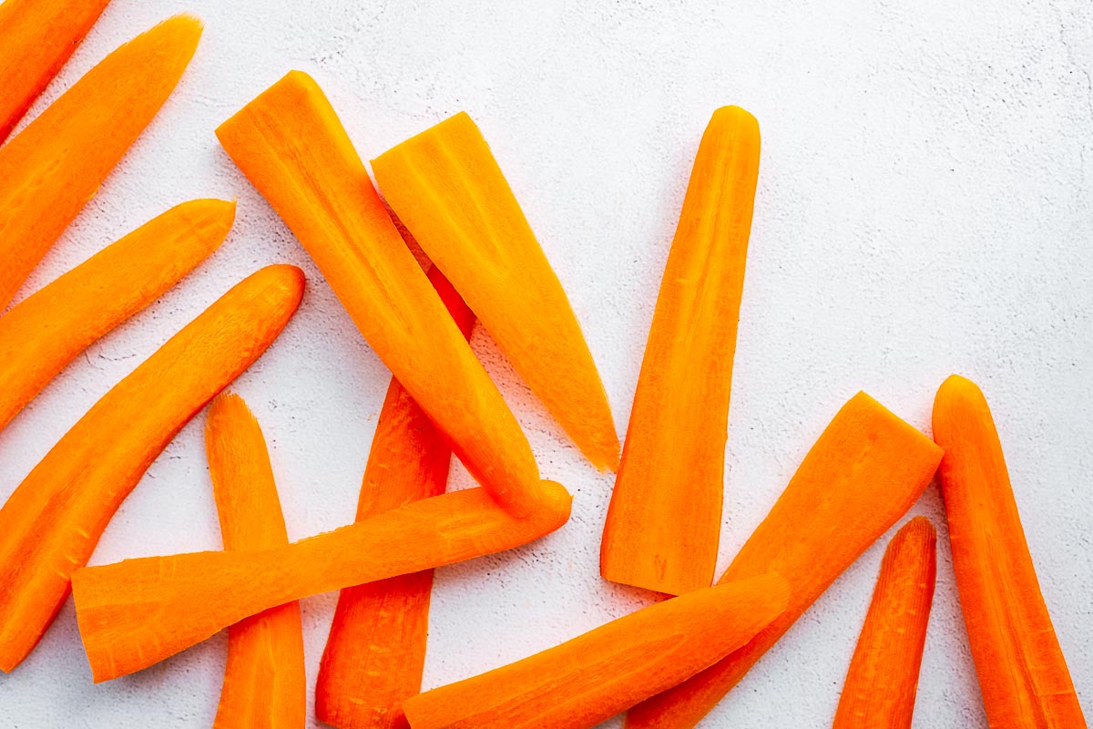 Large slices of carrots on a concrete background.