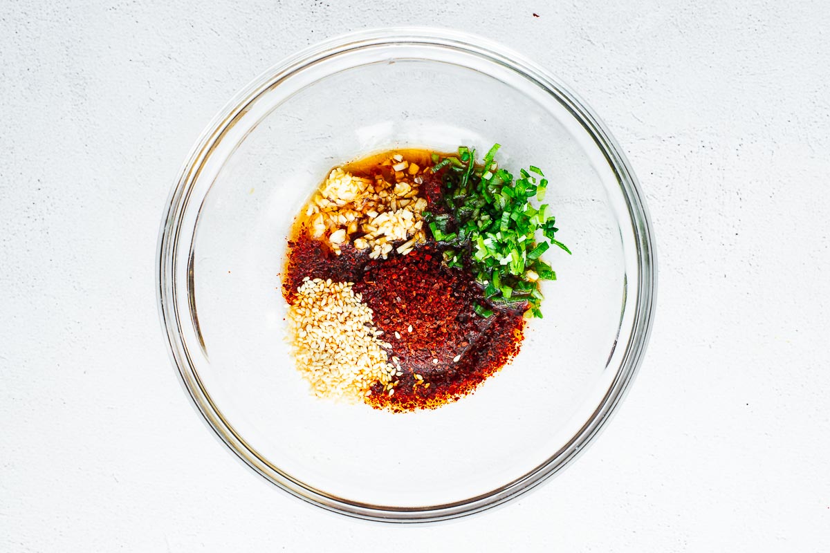 Spicy gochugaru sauce ingredients in a glass bowl.