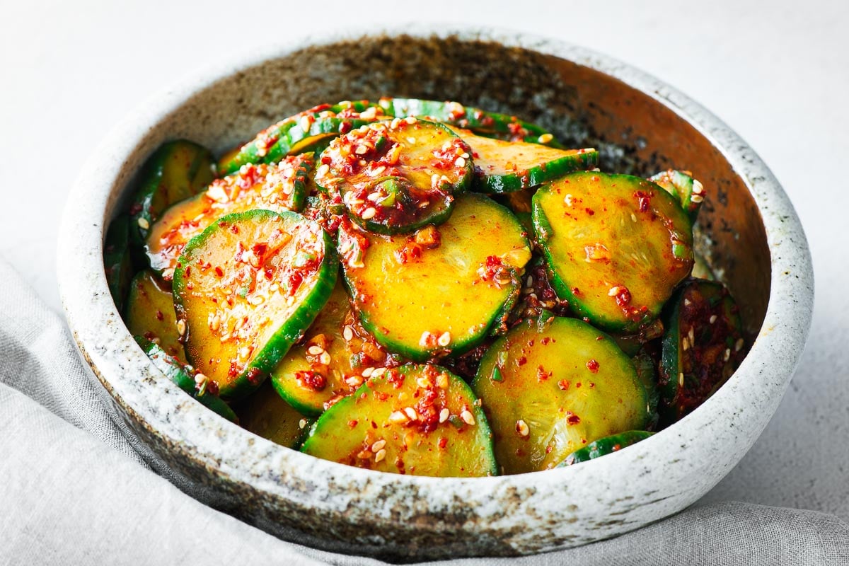 Close-up of spicy cucumber salad (Korean banchan) in a ceramic bowl.