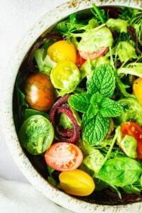 A close-up of a simple salad will avocado green goddess salad dressing.