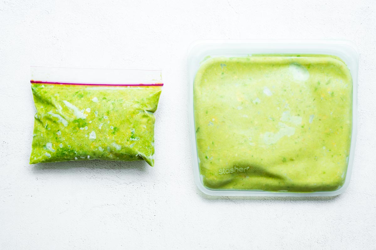 Frozen mashed avocado with lime juice in a plastic freezer bag and in a reusable silicone freezer bag.
