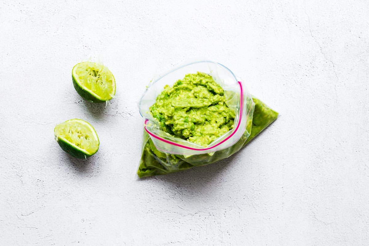 An open plastic freezer bag with mashed avocado viewed from above..