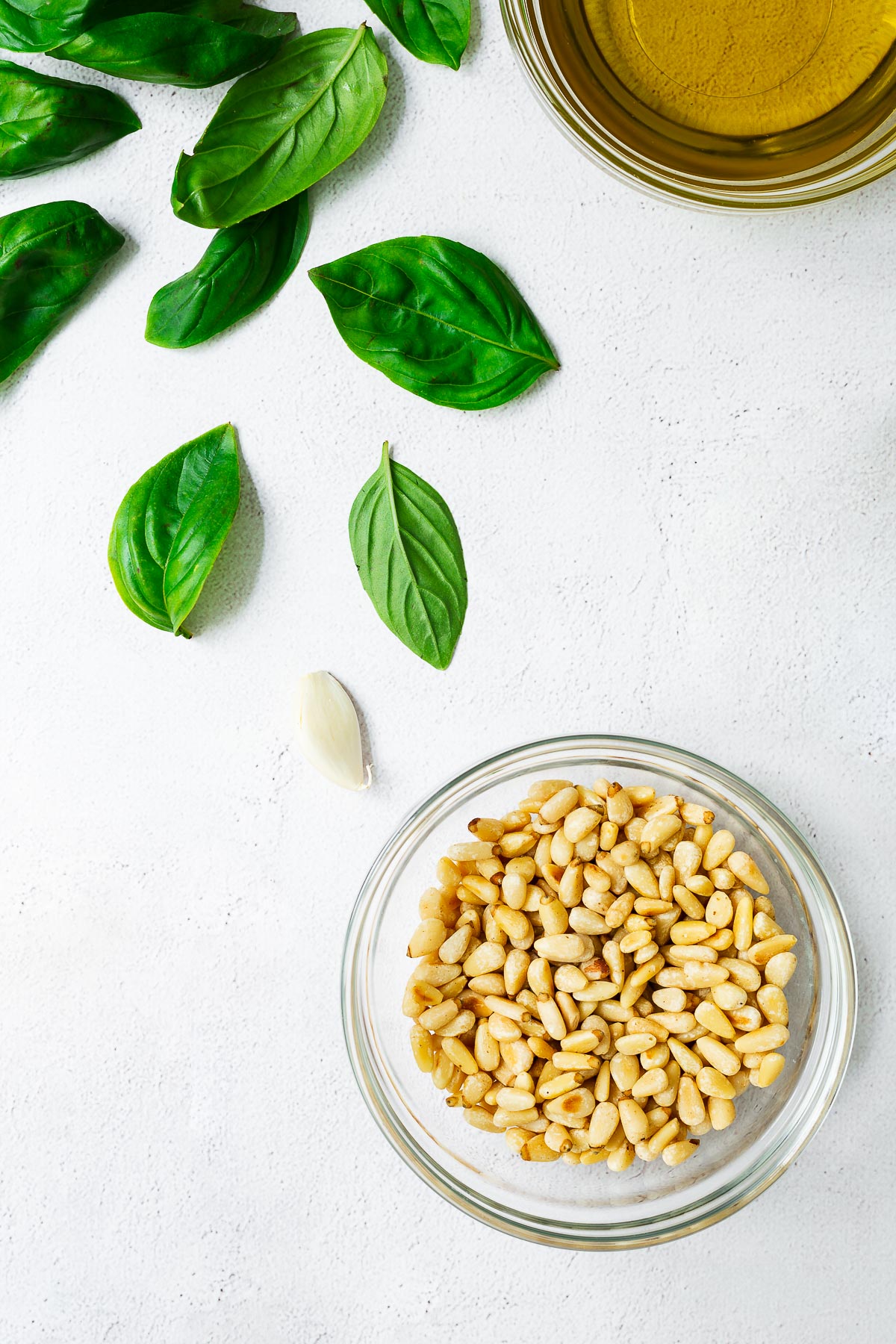 Top down view of pine nuts and basil pesto ingredients.