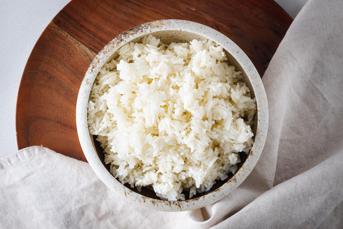 Top down view of a bowl of fluffy white long-grain rice.