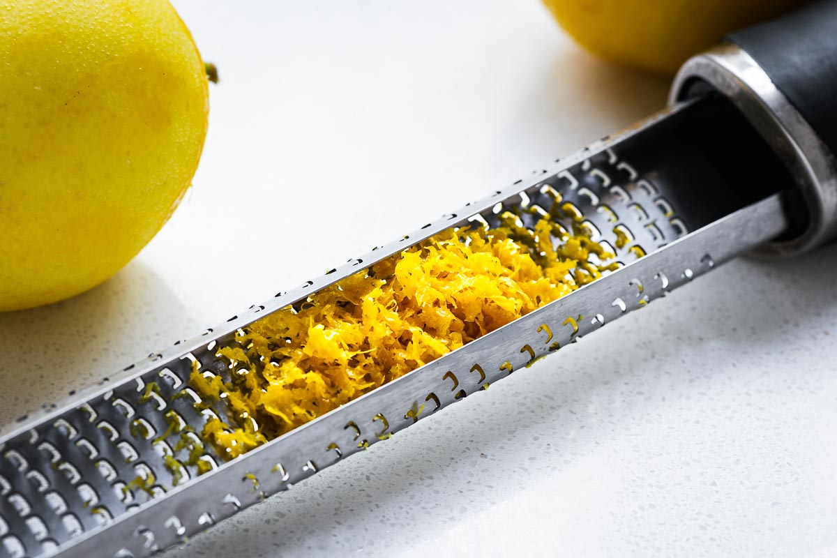 A close-up of a Microplane zester with lemon zest.