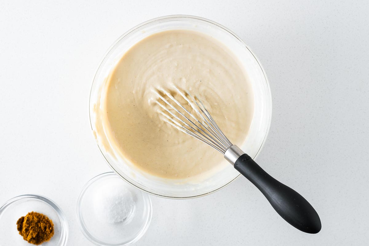 Smooth vegan tahini sauce once enough water is added and the sauce emulsifies.