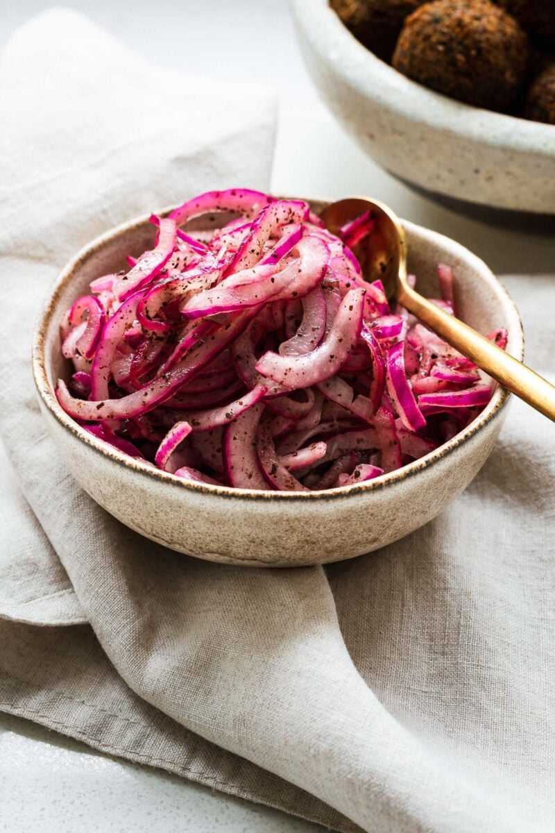 Close-up of red sumac onions in a small bowl.