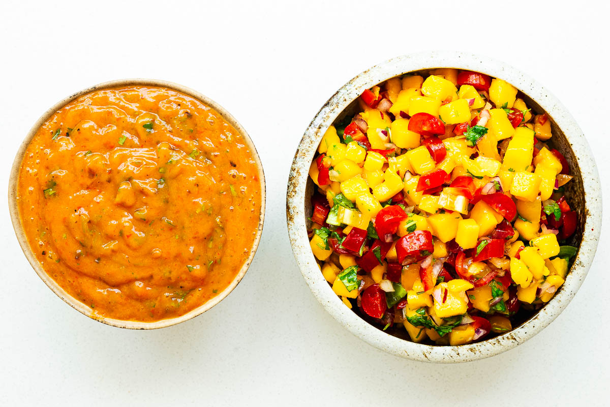 Two bowls of mango habanero salsa, one roasted salsa and one fresh salsa.