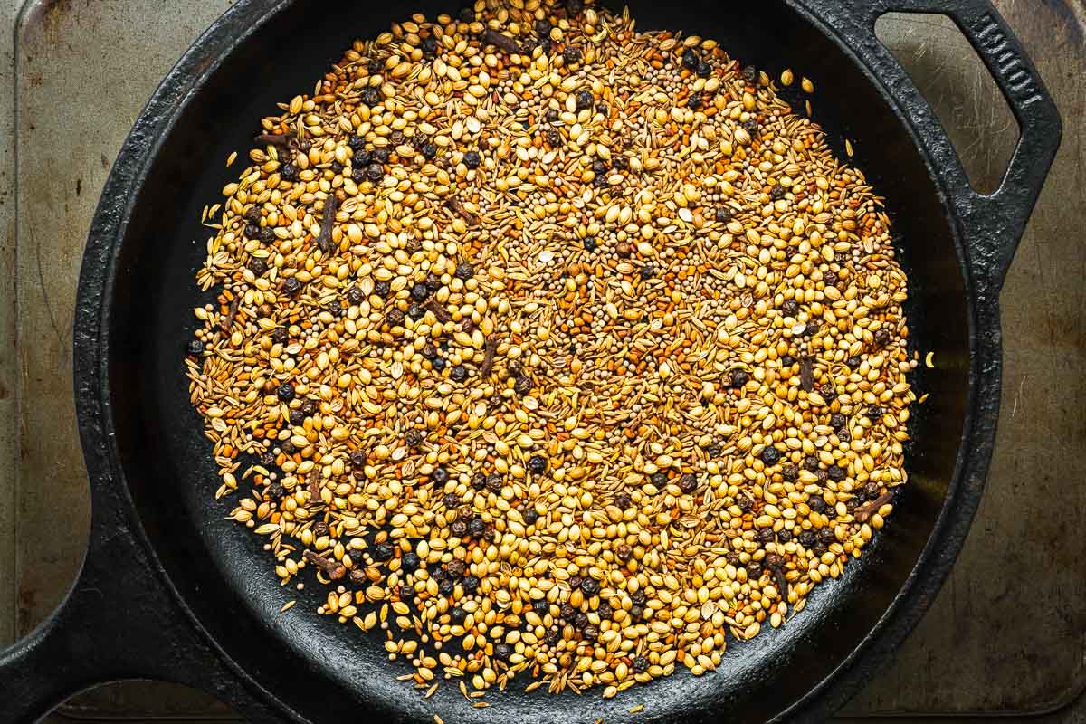 Whole spices being toasted in a dry skillet for homemade curry powder.