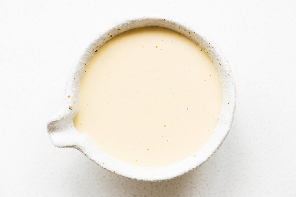 A small bowl with creamy tahini and maple salad dressing viewed from above.