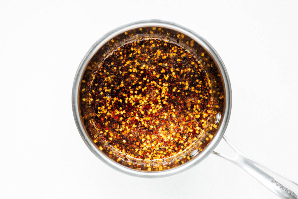 Honey and red pepper flakes in a saucepan warmed to a light simmer to infuse the honey.