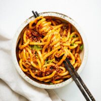 A bowl of udon noodles with a spicy gochujang noodle sauce.