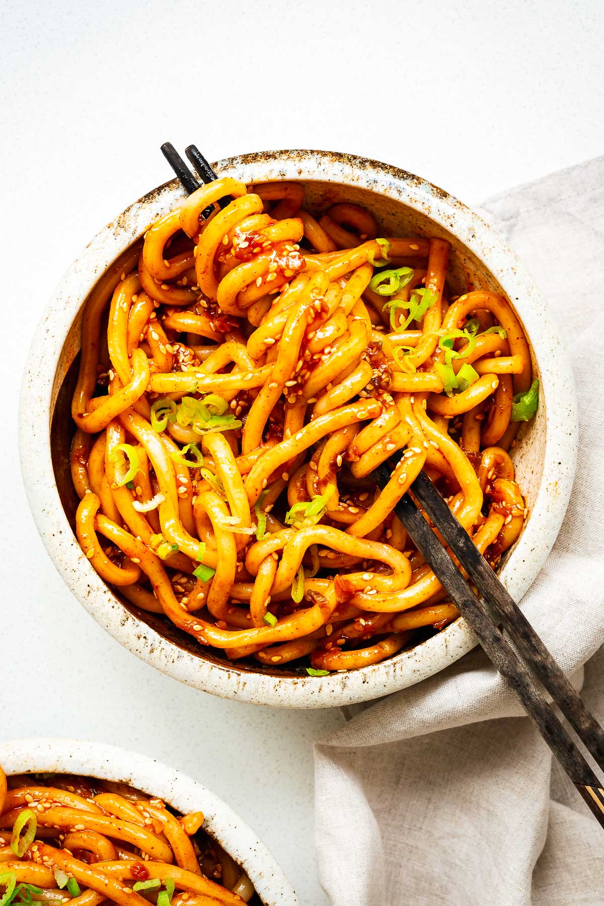 A bowl of udon noodles with a spicy gochujang noodle sauce.