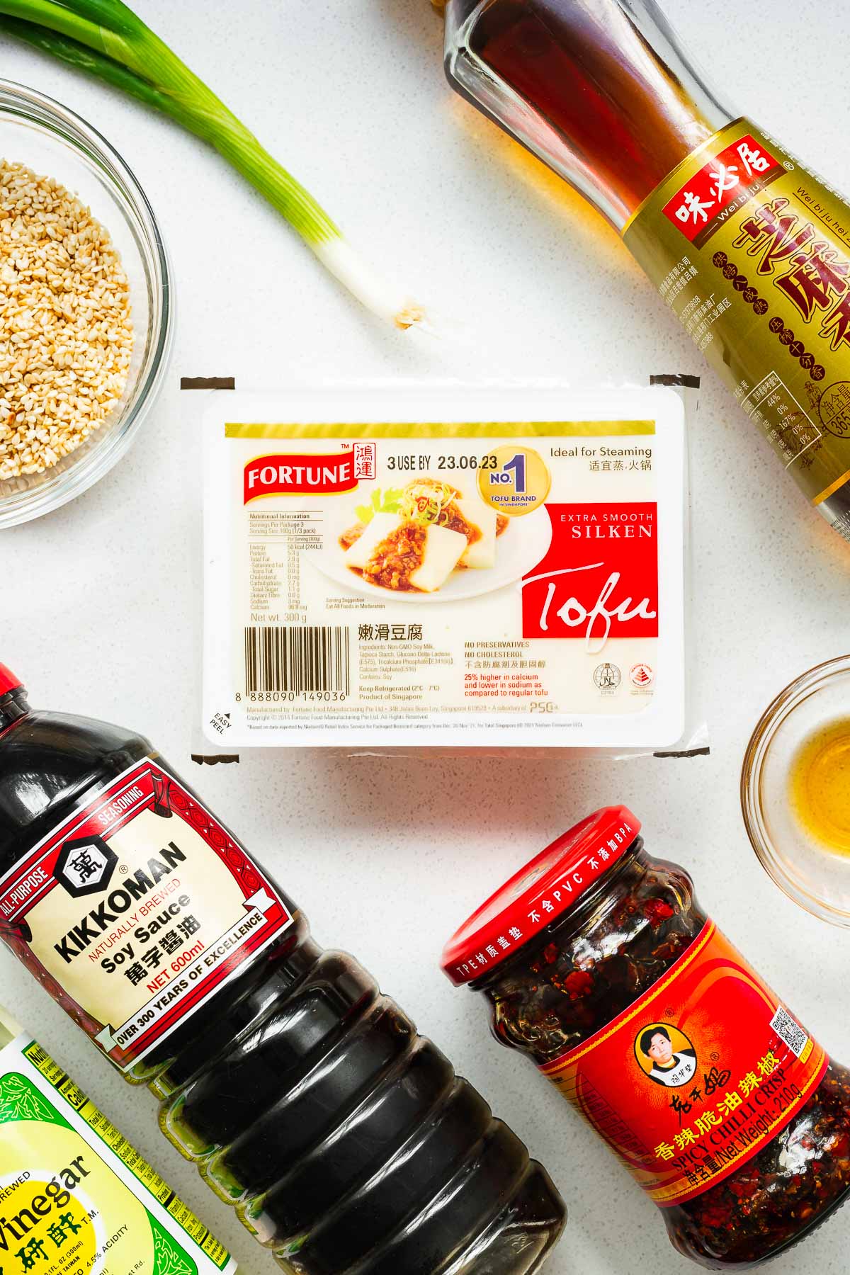 All the ingredients for a spicy soft tofu dish with silken tofu and spicy soy sauce dressing.