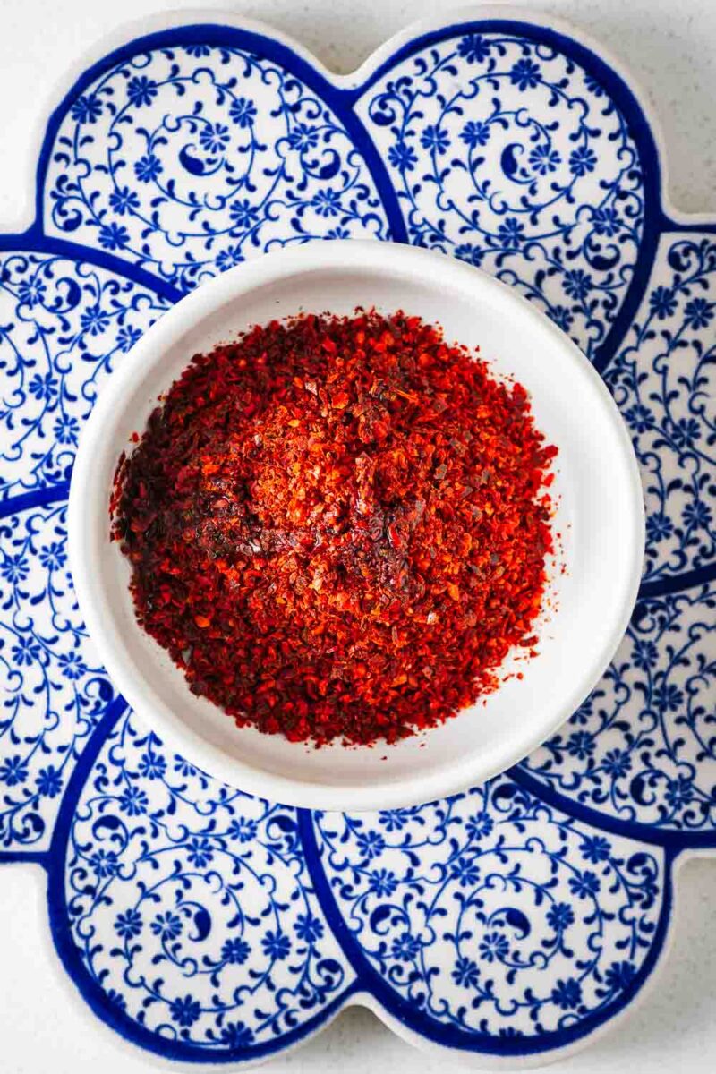 A small white bowl with chilli flakes and sunflower oil viewed from above.