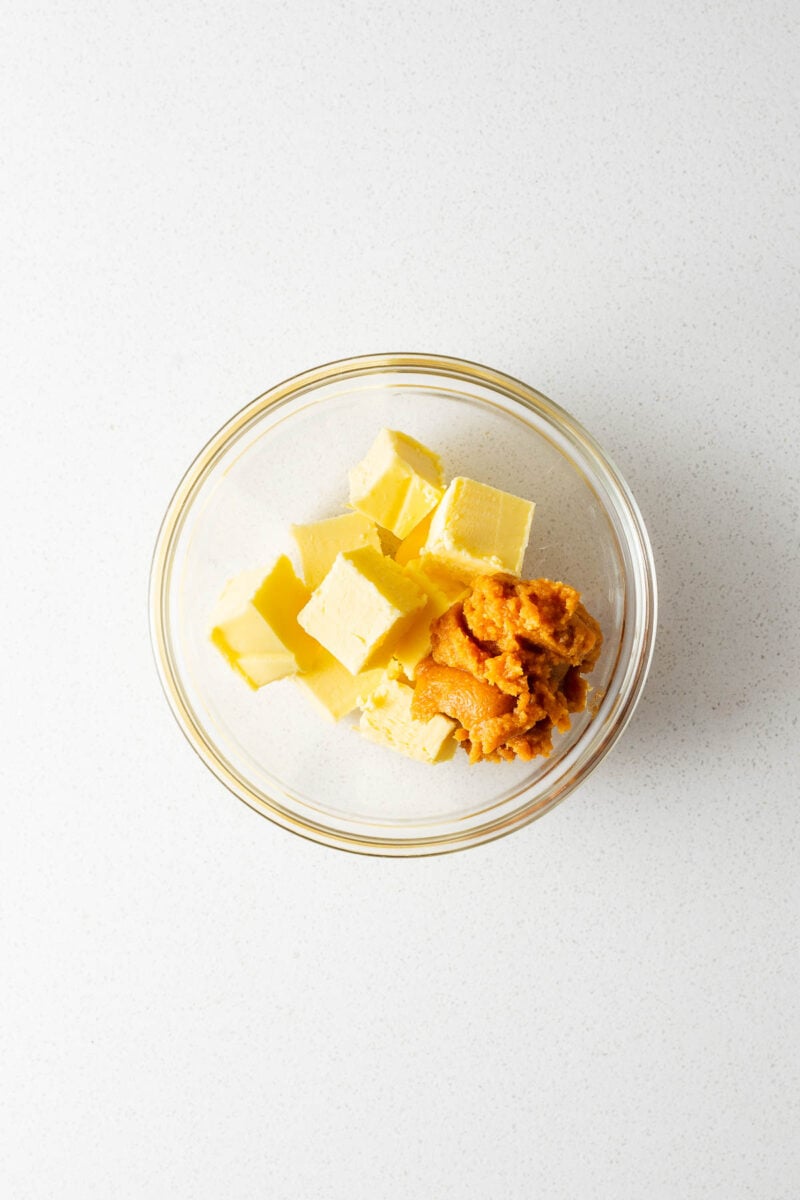 A small glass bowl with cubed room temperature butter and white miso paste.