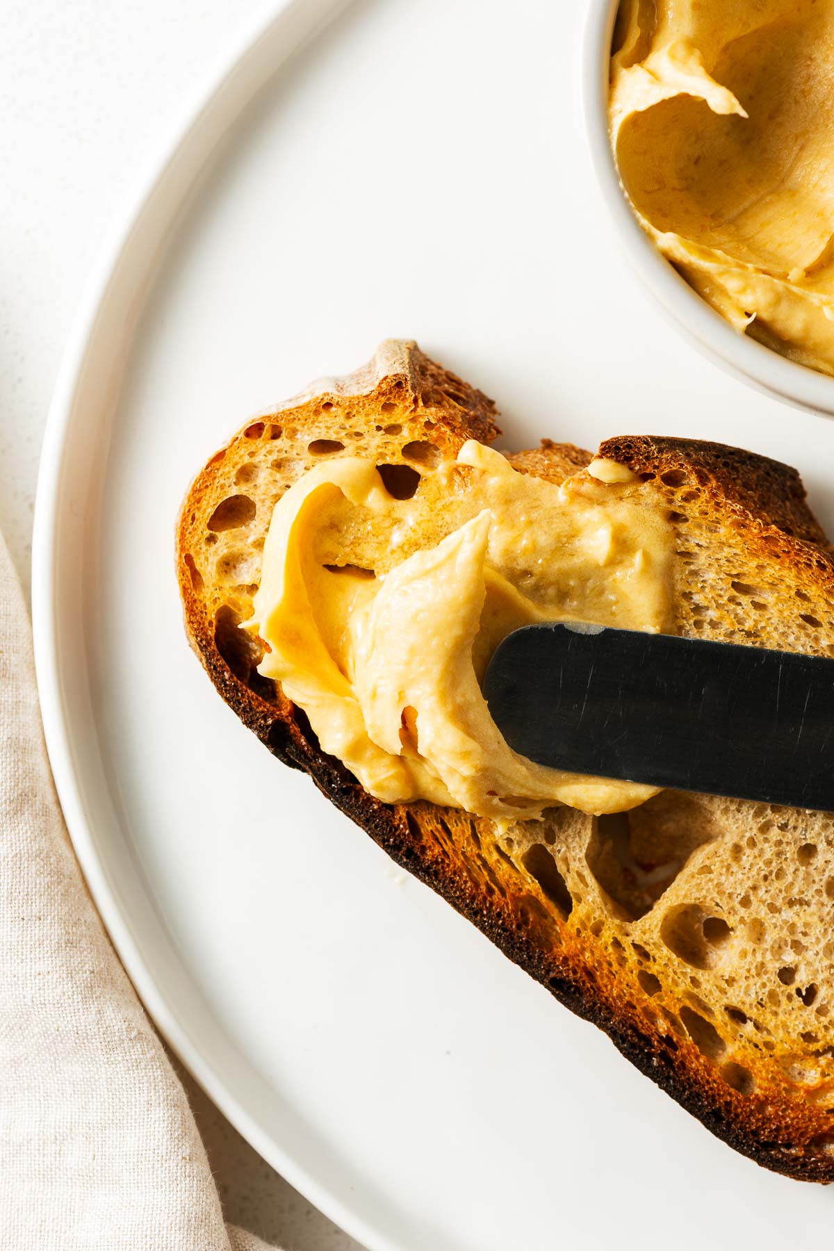 A slice of miso buttered toast on a white plate.