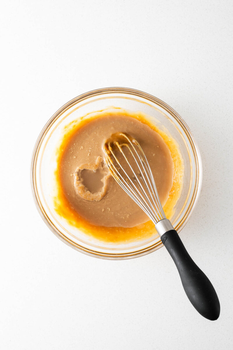 A tablespoon of water floating on top the tahini miso dressing before being whisked in.