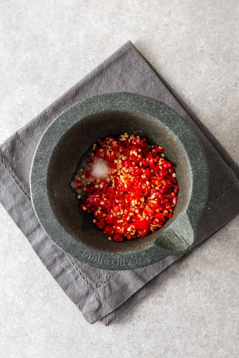 Chopped red chillies in a mortar and pestle.