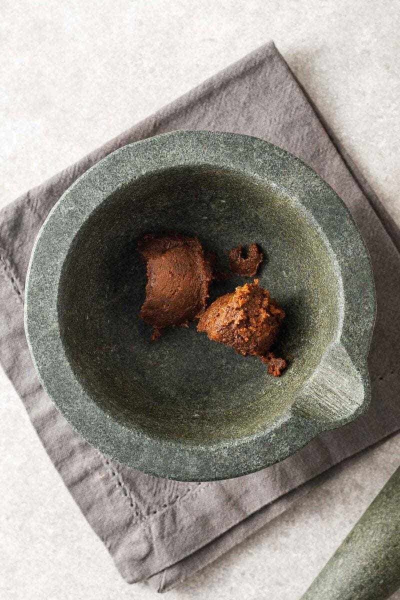 Two tablespoons of doenjang paste in a mortar bowl viewed from above.