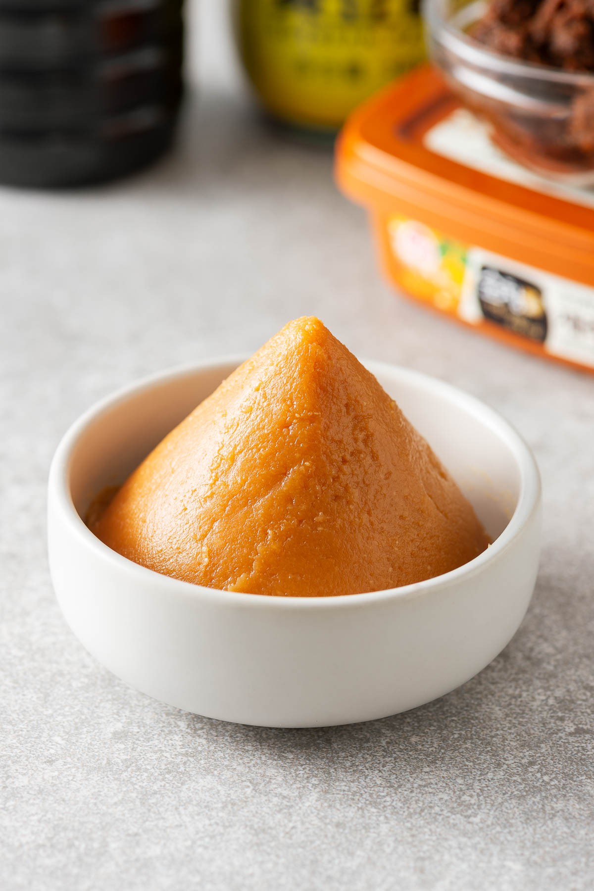 Miso paste in a bowl with some miso substitutes in the background.
