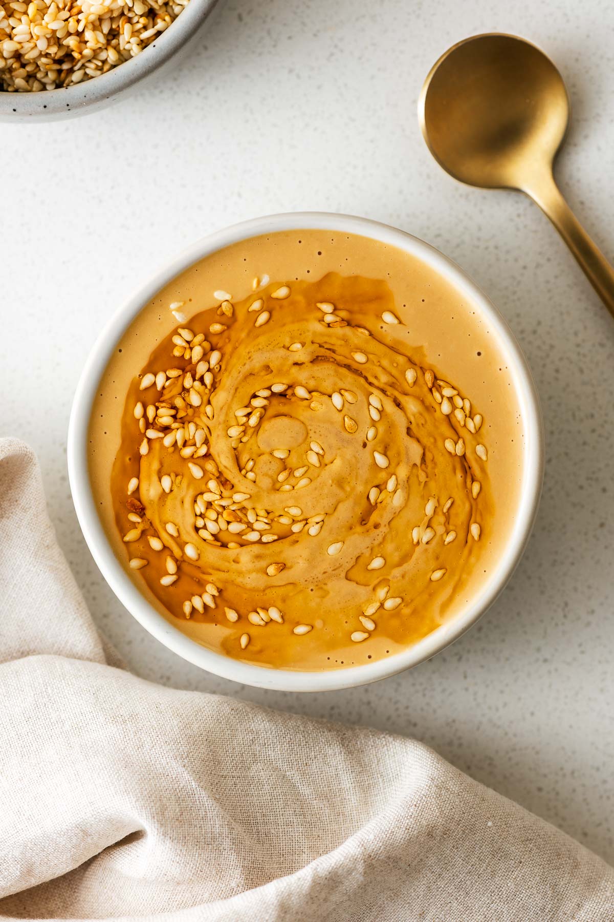 Tahini miso sauce served as a dip drizzled with sesame oil and sprinkled with sesame seeds.