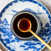 Japanese yakisoba sauce in a glass jar placed on a traditional Japanese ceramic plate.