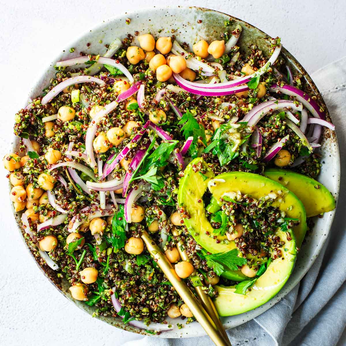 Quinoa salad with basil, kale and almond pesto topped with avocado and a lemon dressing.