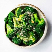 A bowl of Korean broccoli banchan sprinkled with toasted sesame seeds.