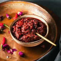A bowl of homemade rose harissa paste on a Middle Eastern serving tray.