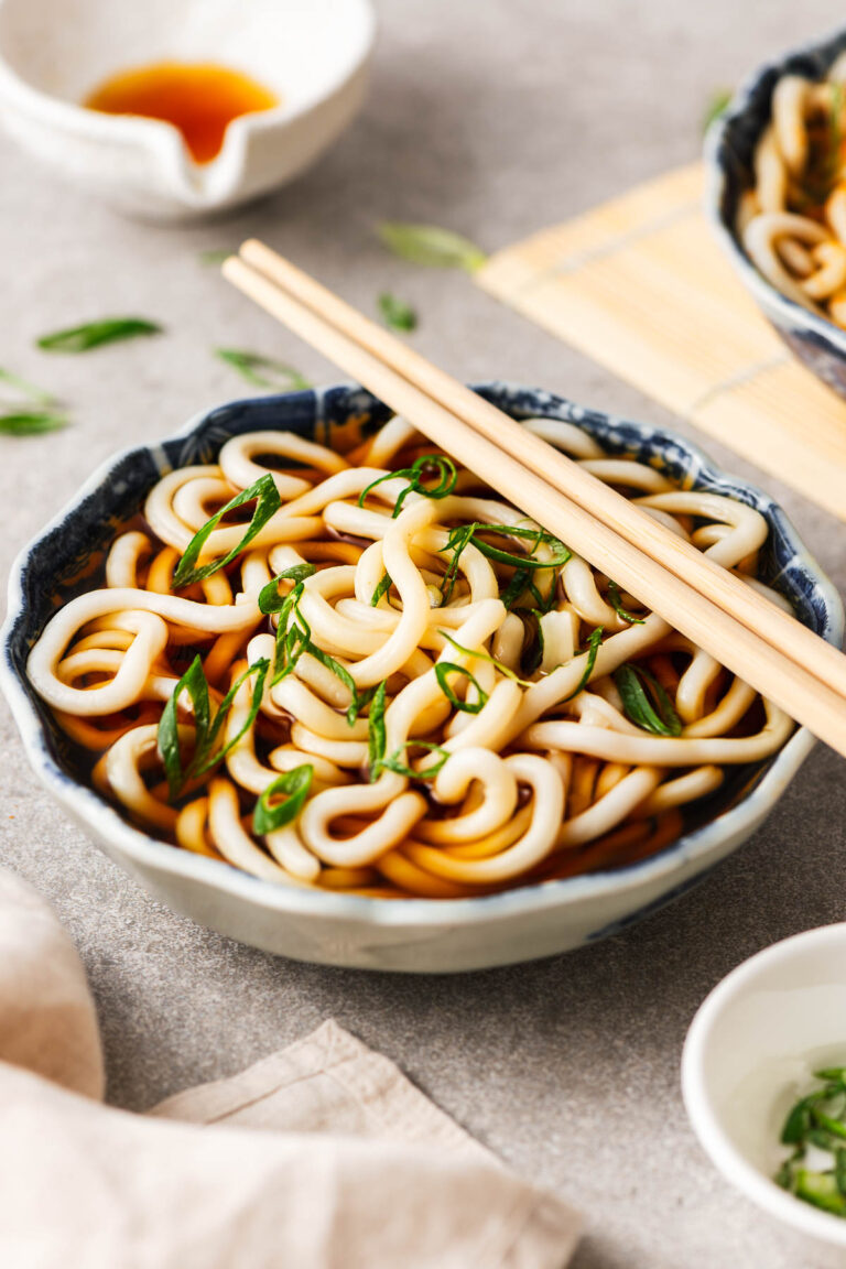 A bowl with kake udon (simple Japanese udon noodle soup) and a pair of chopsticks.