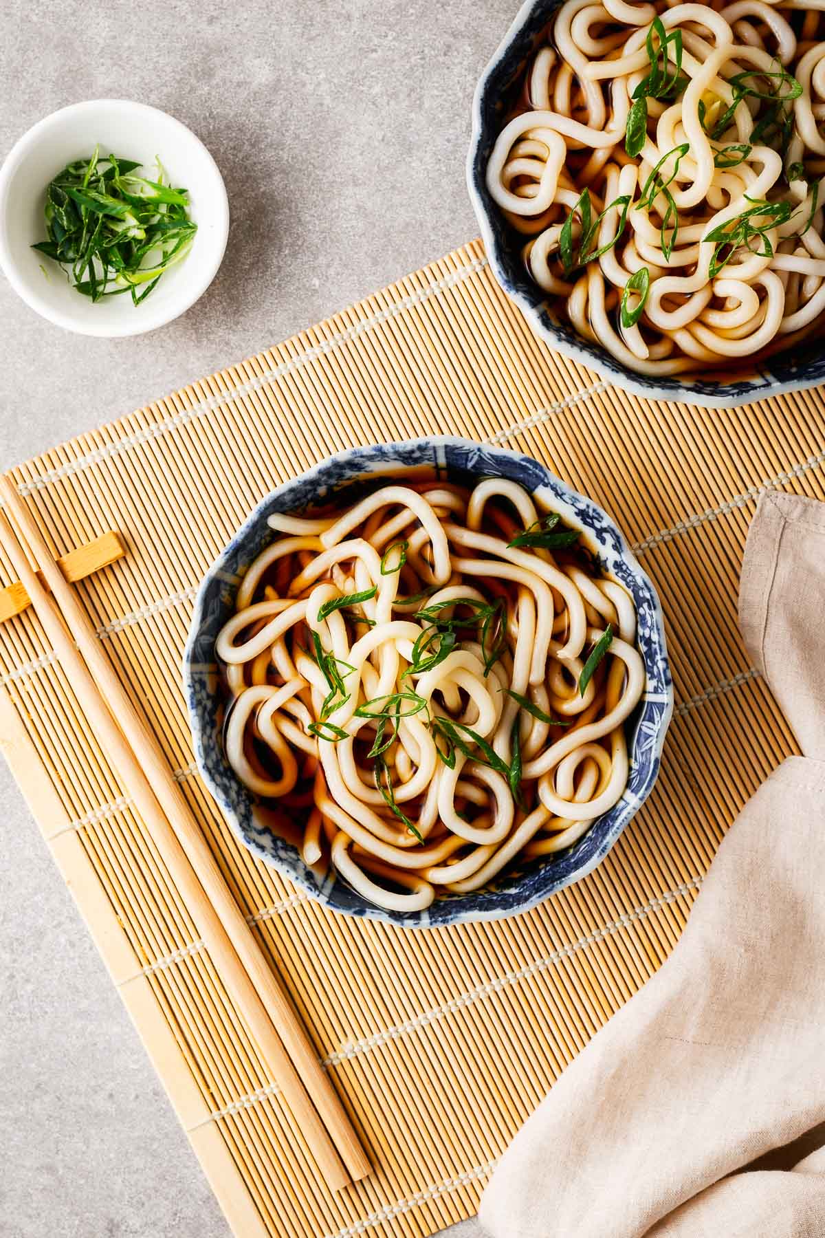 Kake udon in Japanese ceramic bowls topped simply with sliced green onions.