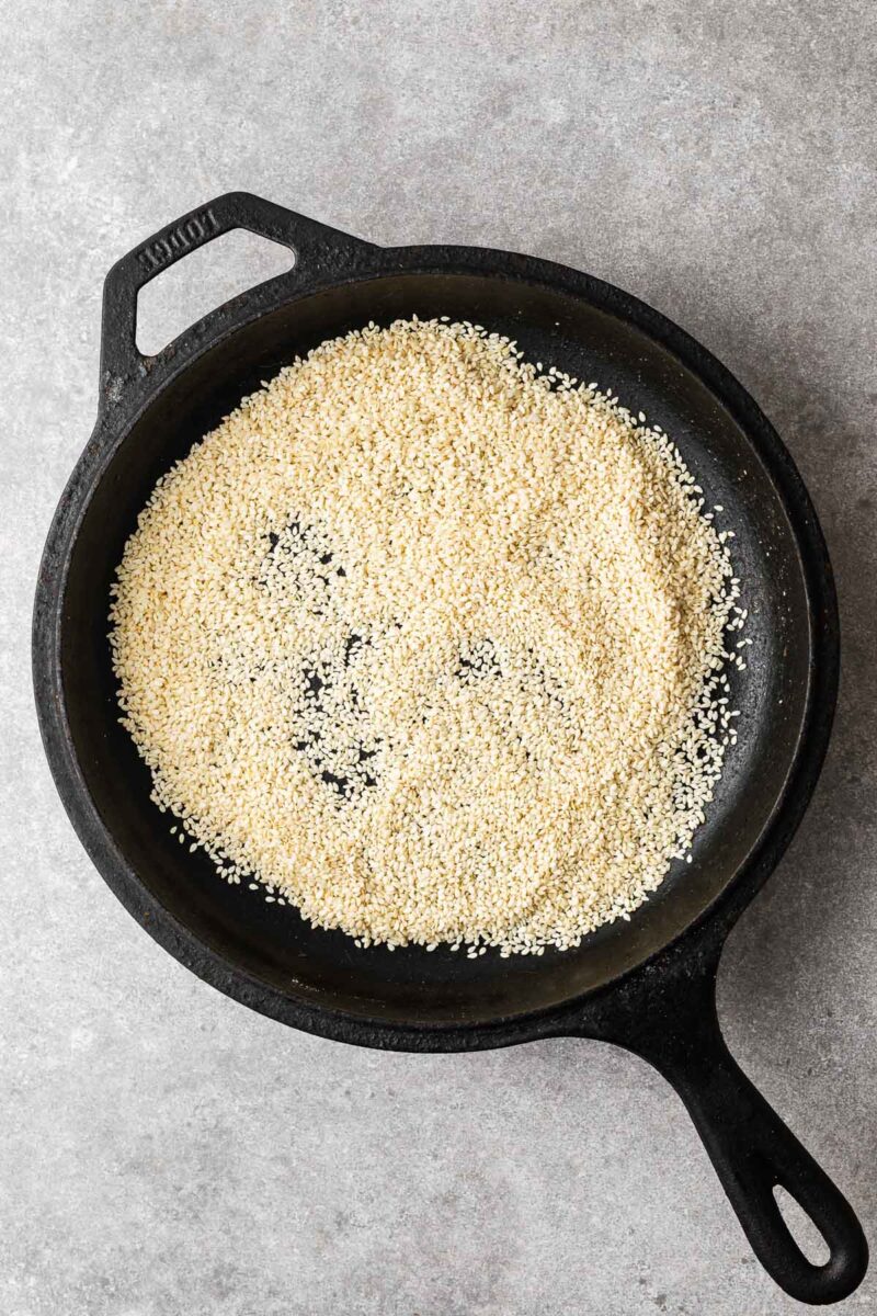 Raw sesame seeds in a skillet.