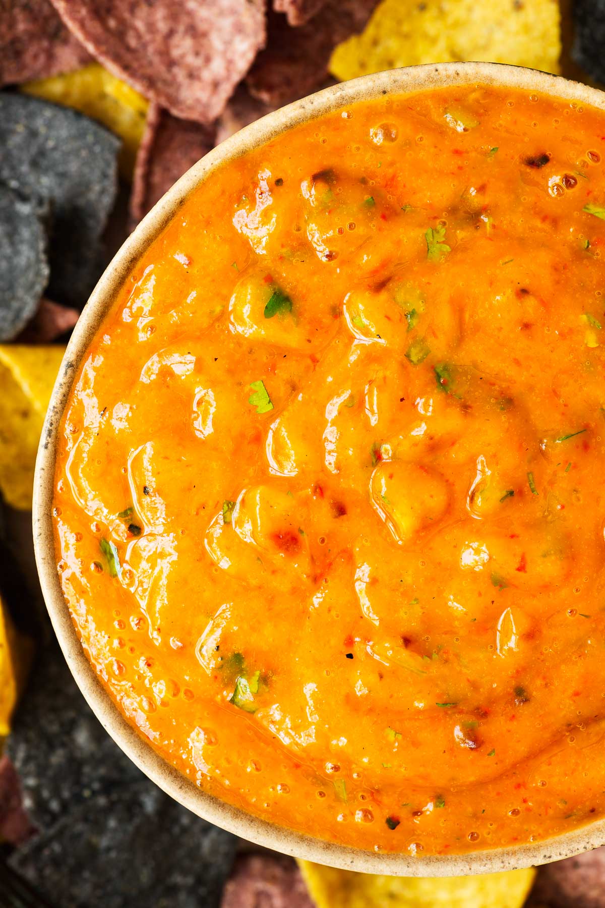 A bowl of vibrant roasted mango salsa blended into a smooth spicy sauce.